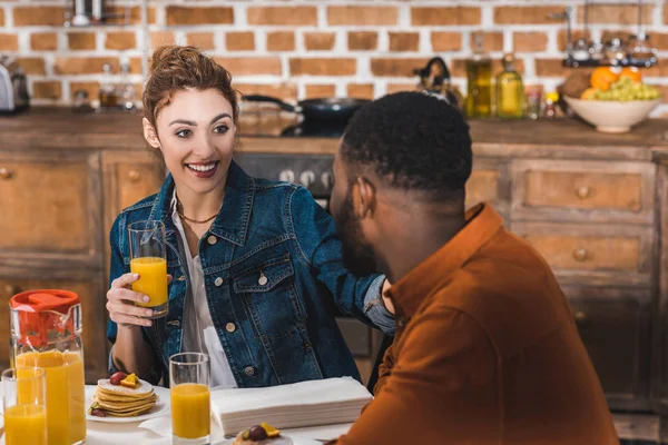 Beau jeune couple multiethnique heureux prenant le petit déjeuner ensemble à la maison — Photo de stock