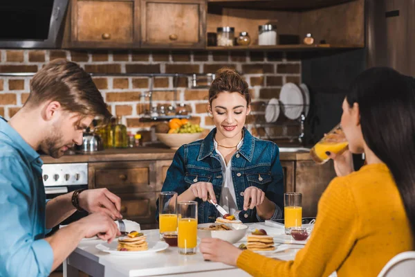 Jeunes amis prenant le petit déjeuner ensemble à la maison — Photo de stock