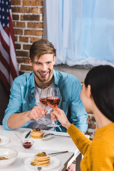 Felice giovane coppia clinking bicchieri di vino mentre si mangia insieme a casa — Foto stock
