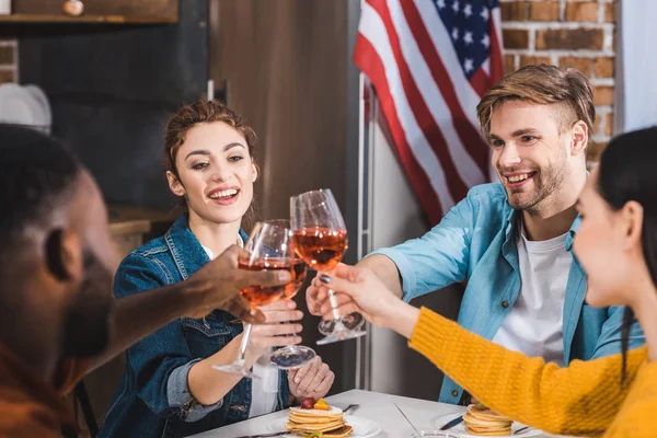 Tiro cortado de jovens amigos multiétnicos felizes batendo copos de vinho — Fotografia de Stock