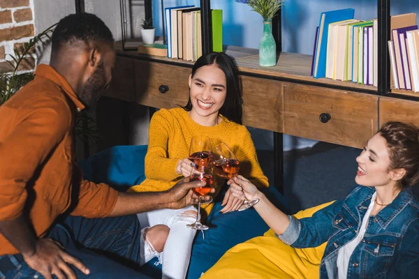 Glückliche junge multiethnische Freunde, die gemeinsam Weingläser klirren — Stockfoto