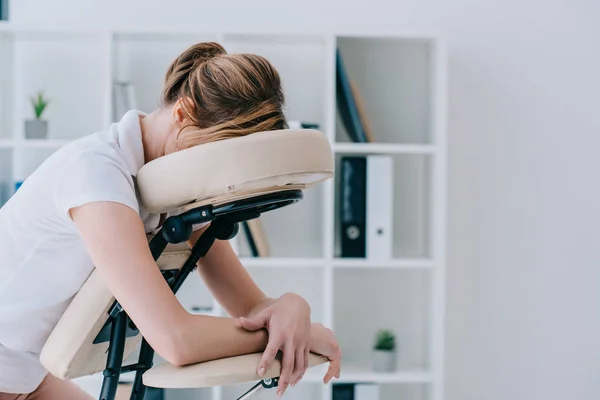 Portrait en gros plan de la femme assise sur une chaise de massage au bureau — Photo de stock