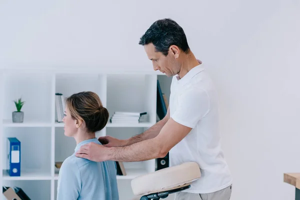 Handsome mature masseur doing office massage for businesswoman — Stock Photo