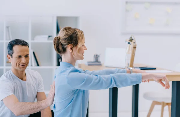 Businesswoman working out with personal trainer at office — Stock Photo