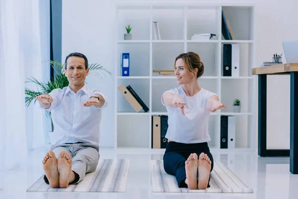 Hombre de negocios con su entrenador practicando yoga en Dandasana posan en oficina - foto de stock