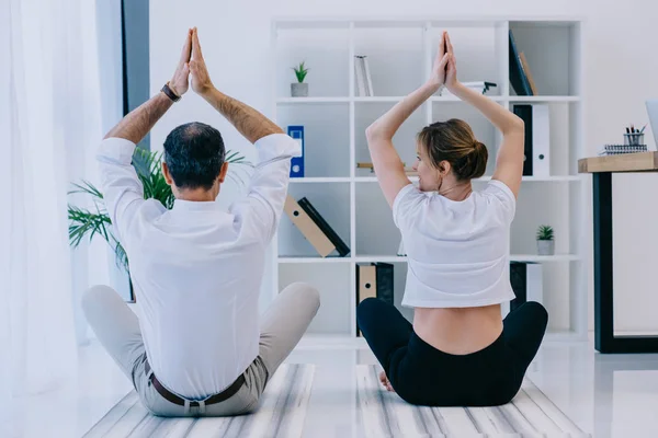 Hombre de negocios con su entrenador practicando yoga en Lotus posan en la oficina - foto de stock