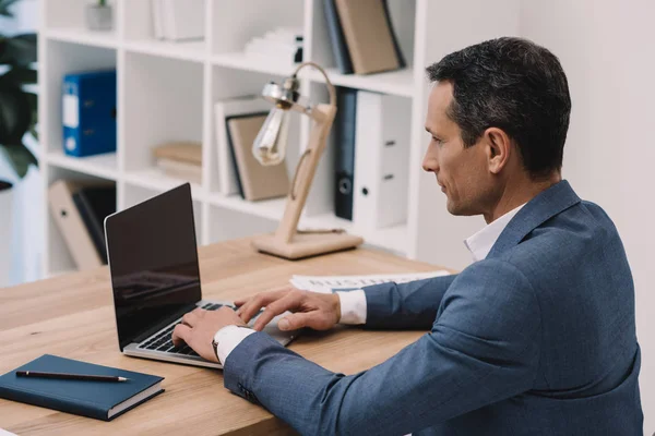 Bonito maduro empresário usando laptop no local de trabalho — Fotografia de Stock