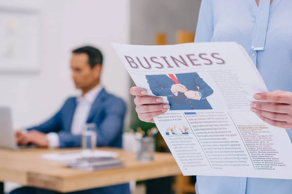Tiro cortado de empresária lendo jornal de negócios no escritório — Fotografia de Stock