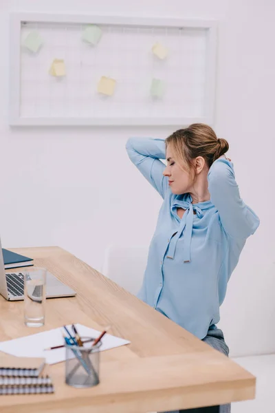 Attrayant femme d'affaires faisant côté torsion au bureau — Photo de stock