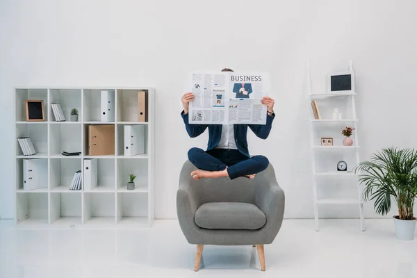 Geschäftsfrau liest Zeitung, während sie im Büro schwebt — Stockfoto