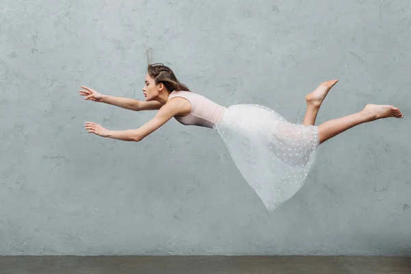 Bela jovem mulher no vestido pairando e olhando para longe no cinza — Fotografia de Stock