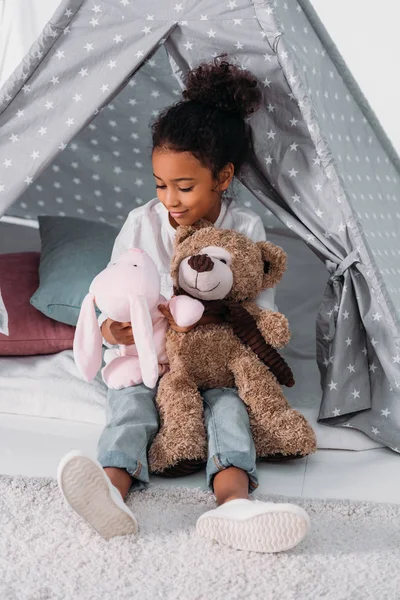 African american kid hugging soft toys — Stock Photo