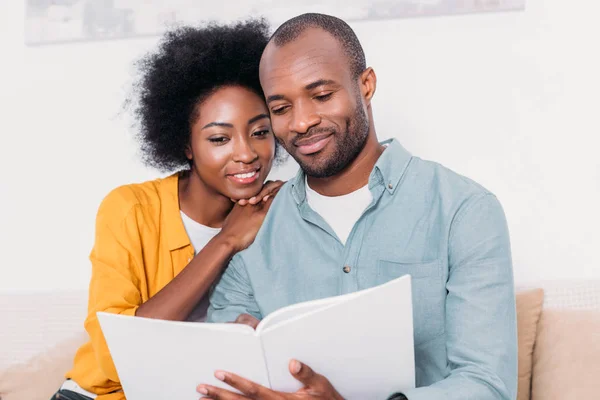 Casal afro-americano ler livro juntos em casa — Fotografia de Stock