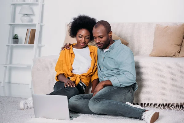 Africano americano pareja viendo película en portátil en casa - foto de stock
