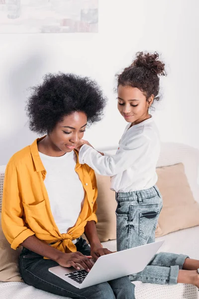 African american mother and daughter looking at laptop at home — Stock Photo