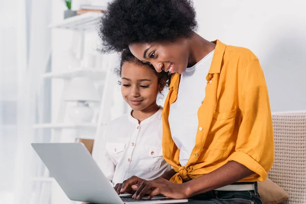 African american mother and daughter looking at laptop at home — Stock Photo