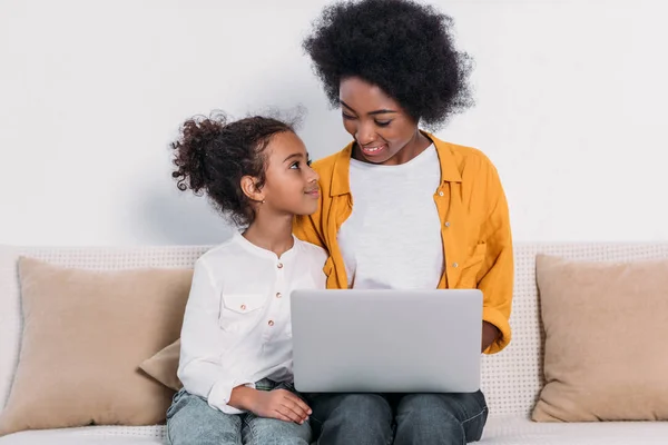 Afroamericana madre e hija con portátil en sofá en casa — Stock Photo