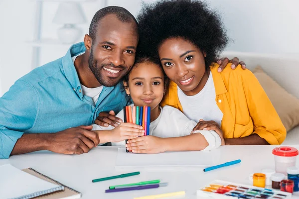 Pais e filha afro-americanos com canetas de feltro olhando para a câmera em casa — Fotografia de Stock