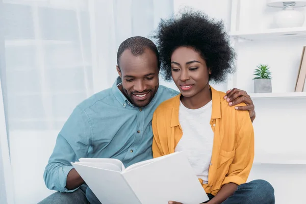 Afrikanisches amerikanisches Paar liest gemeinsam Buch zu Hause — Stockfoto
