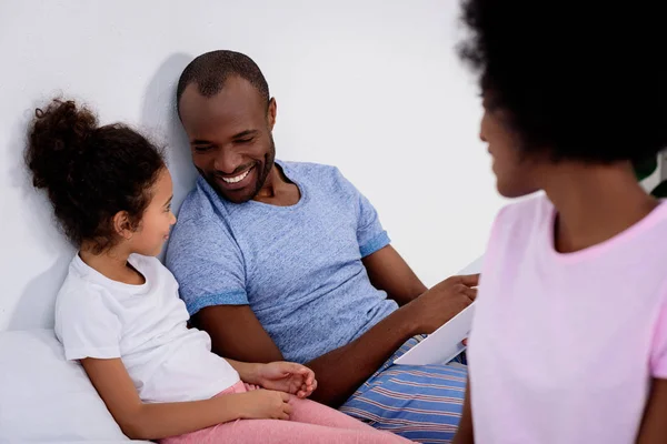 Smiling african american parents and daughter looking at each other at home — Stock Photo