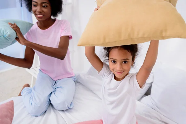 African american mother and daughter holding pillows — Stock Photo