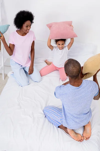 High angle view of african american parents and daughter fighting with pillows — Stock Photo