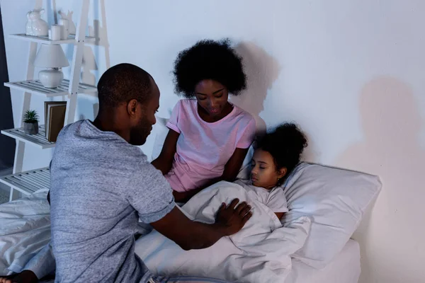 African american parents sitting near sleeping daughter at home — Stock Photo