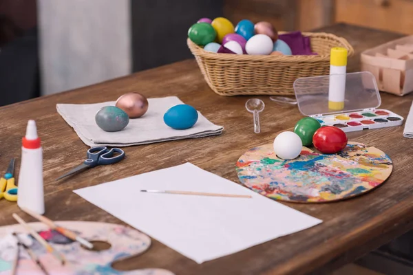 Huevos de Pascua pintados con pinturas de acuarela sobre mesa de madera - foto de stock