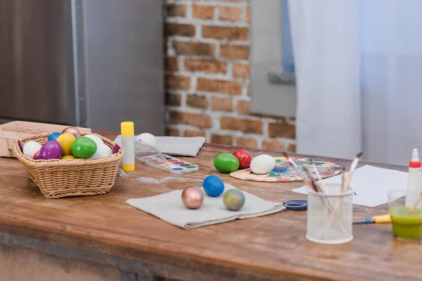 Oeufs de Pâques peints et pinceaux sur table en bois — Photo de stock