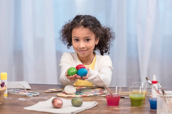 Bambino afro-americano che mostra le uova di Pasqua dipinte in mano e guarda la fotocamera — Foto stock