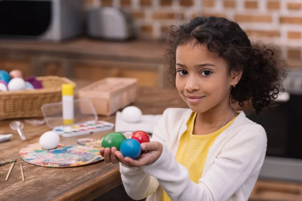 Bambino africano americano che tiene le uova di Pasqua dipinte in mano e guarda la macchina fotografica — Foto stock