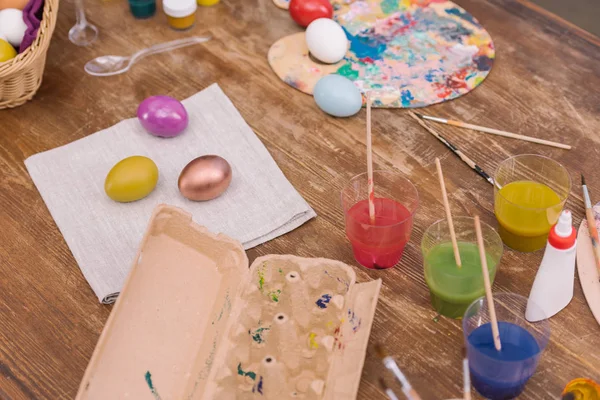 Bandeja de ovo vazia e ovos de galinha pintados para a Páscoa na mesa — Fotografia de Stock