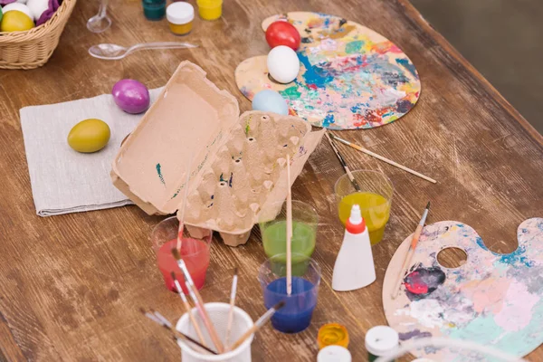 Empty egg tray and painted chicken eggs for easter on table — Stock Photo