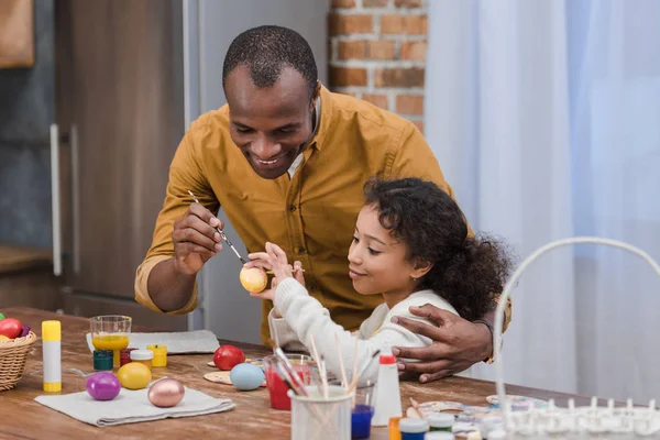 Heureux afro-américain père et fille peinture Pâques oeufs — Photo de stock