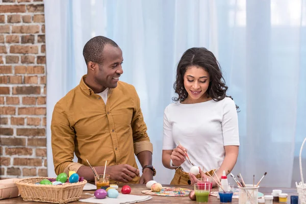 African american couple painting easter eggs — Stock Photo