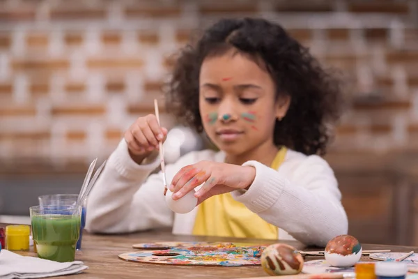African american kid painting easter egg — Stock Photo