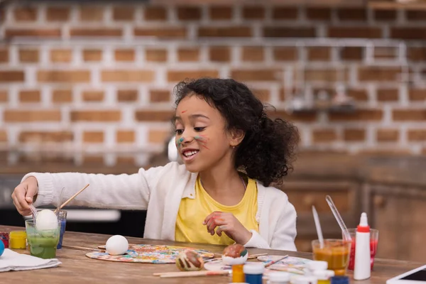 Afro-américain enfant peinture Pâques oeuf en verre avec de la peinture — Photo de stock