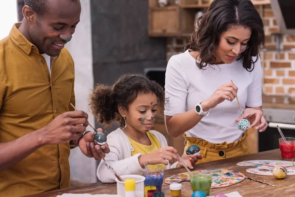 African american parents and daughter painting easter eggs — Stock Photo