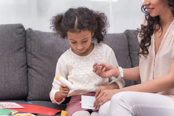 Cropped image of african american mother helping daughter to make greeting card on mothers day — Stock Photo