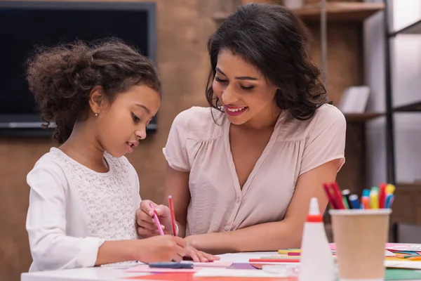 Madre afroamericana e hija dibujando tarjeta de felicitación en el día de las madres - foto de stock