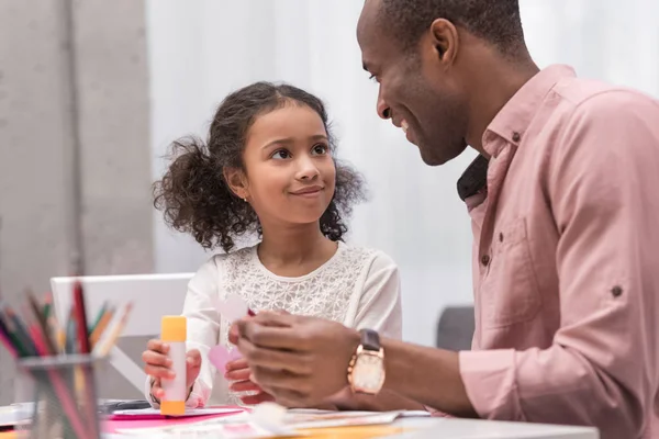 Felice afro-americano padre e figlia facendo biglietto di auguri il giorno delle madri e guardandosi l'un l'altro — Foto stock