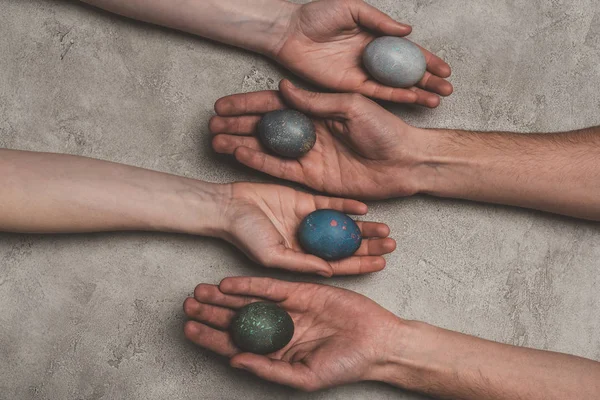 Cropped view of hands with shabby easter eggs on concrete surface — Stock Photo