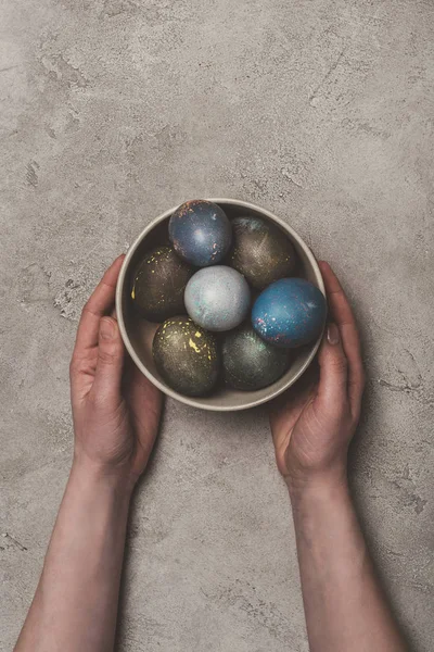 Cropped view of man holding bowl with easter eggs — Stock Photo