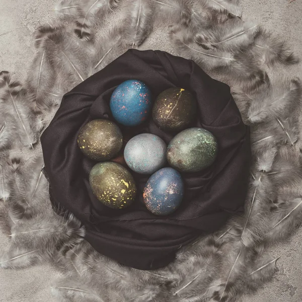 Vista superior de huevos de Pascua en el nido con plumas - foto de stock