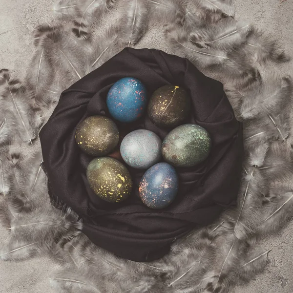Top view of shabby easter eggs in nest with feathers — Stock Photo