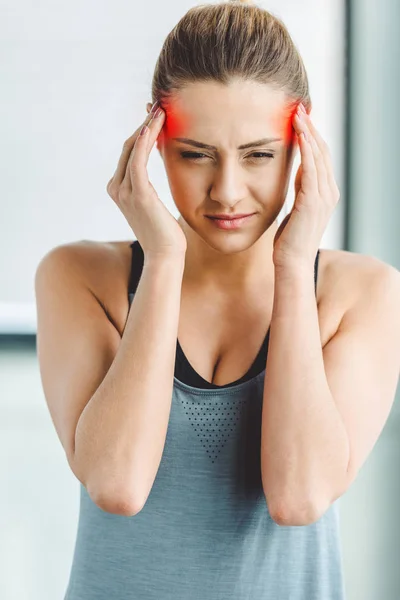 Porträt einer jungen Frau in Sportkleidung, die Kopfschmerzen hat — Stockfoto