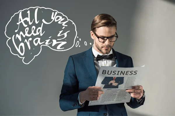 Ritratto di bell'uomo d'affari elegante in occhiali che legge il giornale e tutto ciò che serve è un'iscrizione cerebrale su grigio — Foto stock