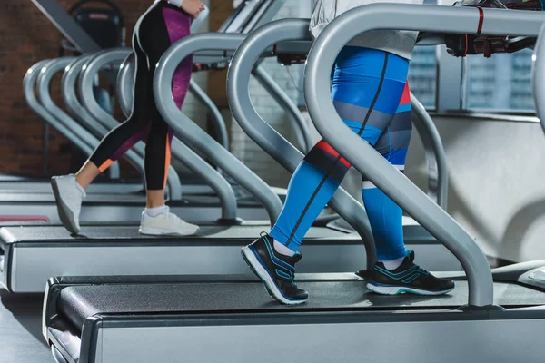 Low section of women training on treadmills — Stock Photo