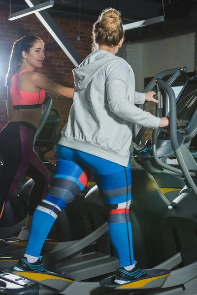 Frauen trainieren im Fitnessstudio auf dem Laufband und sehen sich an — Stockfoto