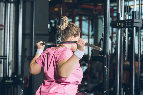 Übergewichtige Frau trainiert an Trainingsgeräten — Stockfoto